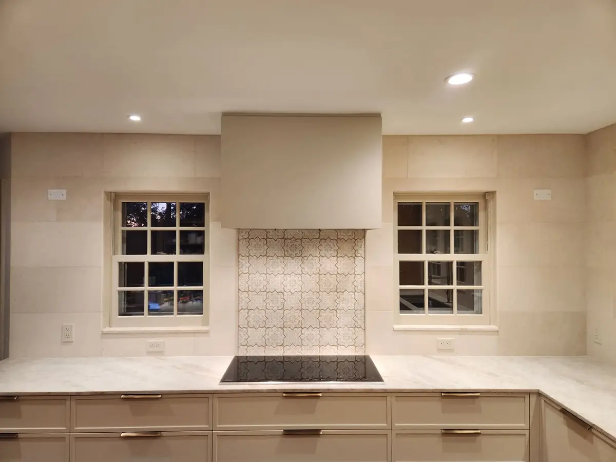Natural Stone 12x24 — 12x24 natural stone tiles with custom design over cooktop.